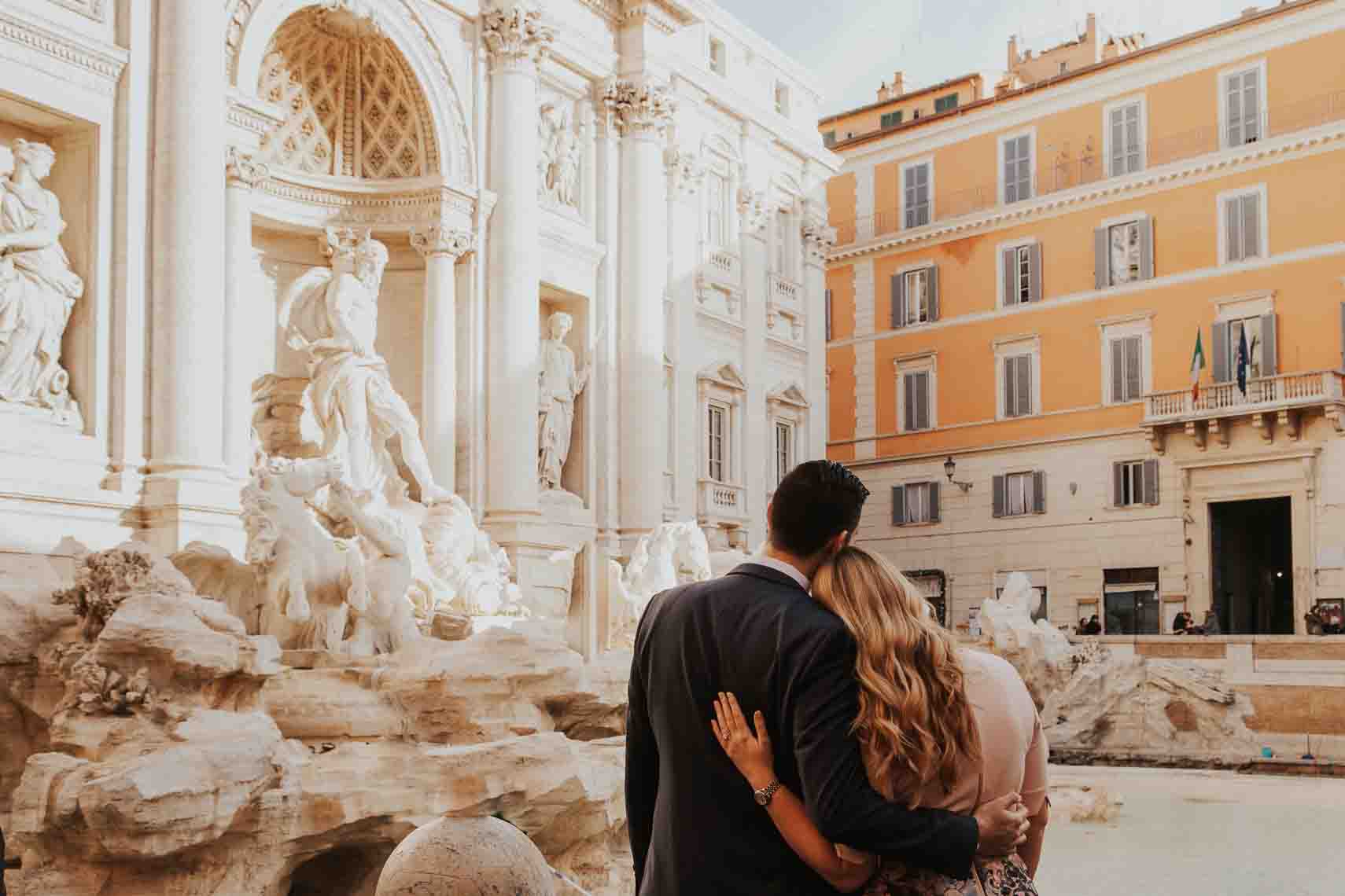 In love couple admiring the Trevi Fountain during an engagement photoshoot in Rome